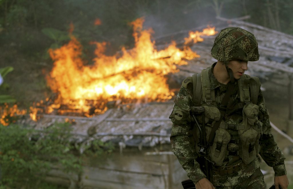 A soldier from the Seventh Division of the Colombian National Army looks on as a make-shift cocaine laboratory burns during an operation to eradicate coca plants in Yali, Antioquia, Colombia. Addressing the world drug problem requires tackling the issue at all stages of the production process. (REUTERS/Fredy Builes) 