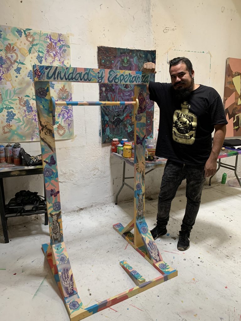 Artist standing by a painted handwashing station 