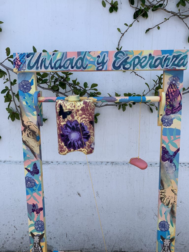 Painted handwashing station with words "Unidad y Esperanza"